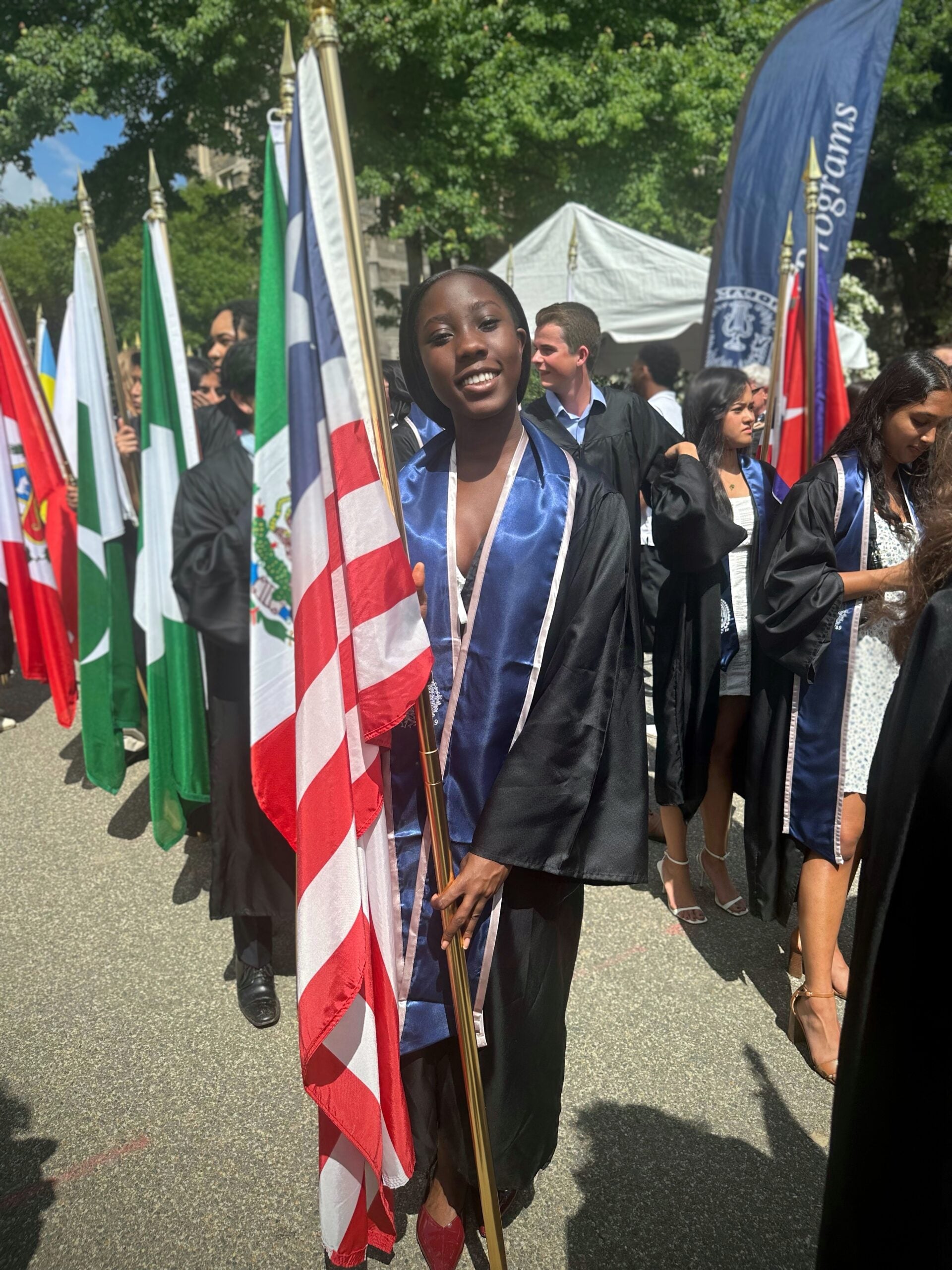 Divinna proudly carrying Liberia's flag during the 2025 Senior Convocation, hopeful that one day she will return home and help create lasting change.