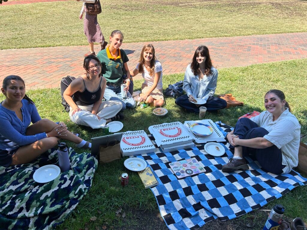 Picnic with six students sitting on blankets.