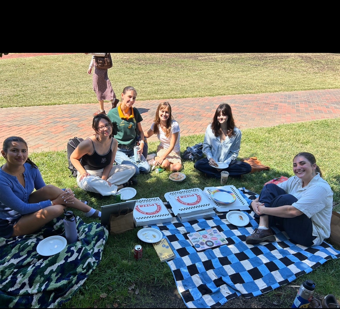 Picnic with six students sitting on blankets.