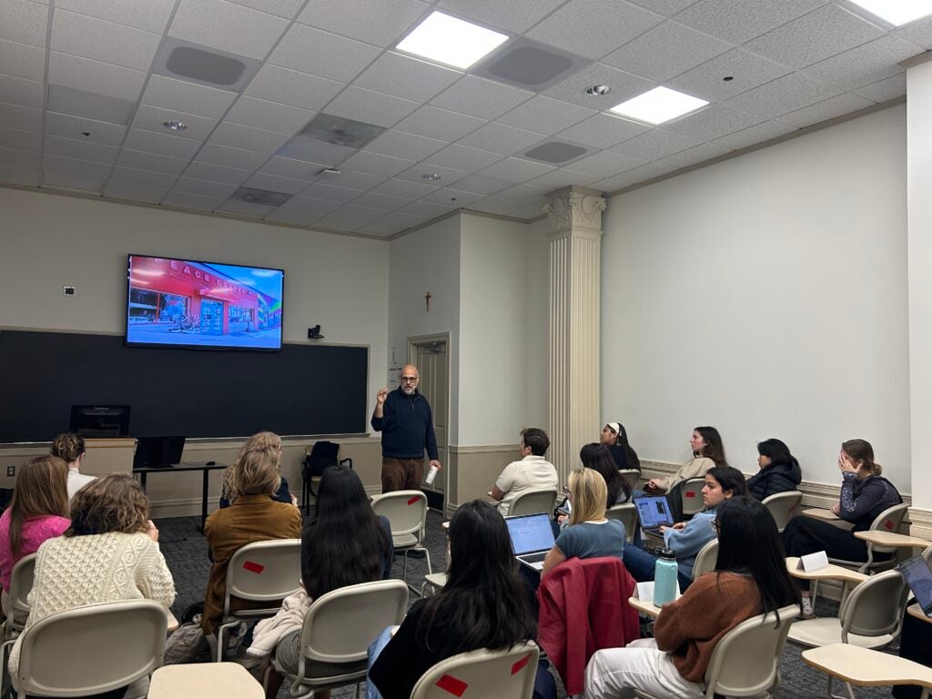 Photo of students in a Georgetown classroom (Maguire 102) watching David Smith present.