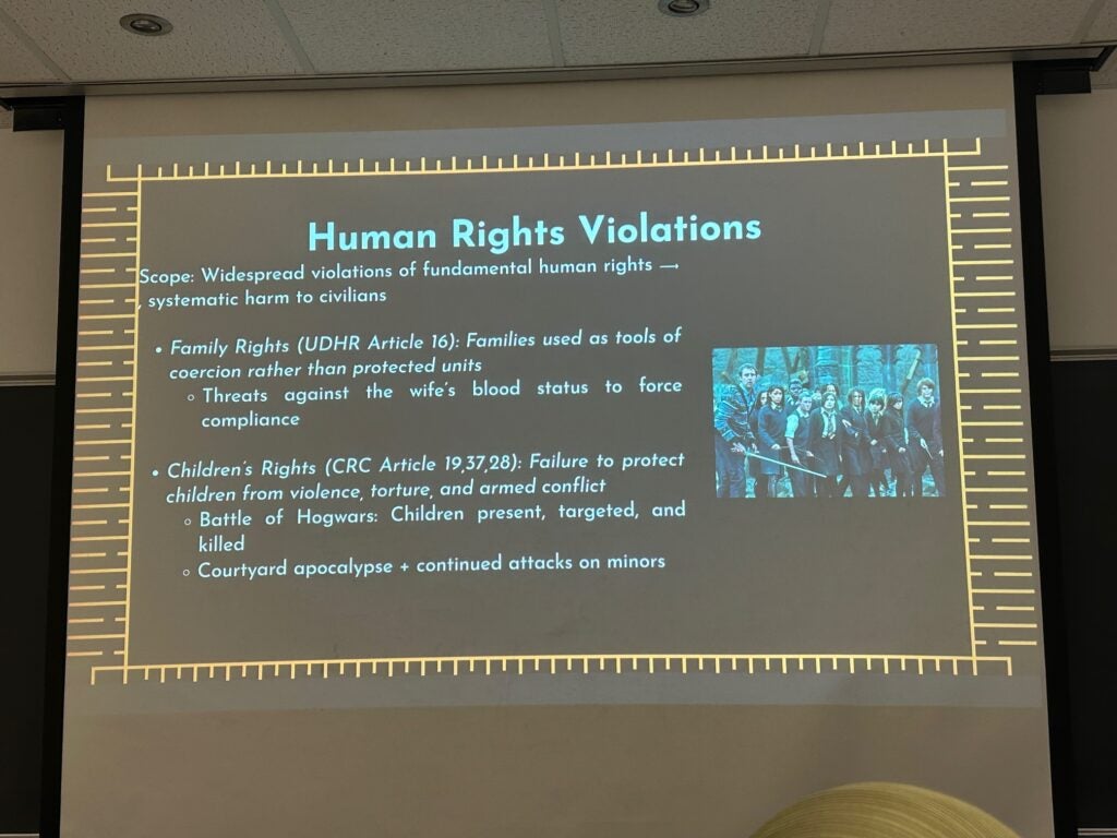 Photo of a slide from a slideshow that has the title "Human Rights Violations", and bullet points like "Family Rights (UDHR Article 16): Families used as tools of coercion rather than protected units."